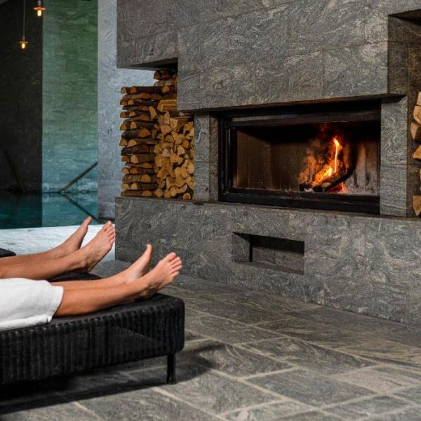 Paar vor dem Kamin mit Wein im Hotel Vejlefjord