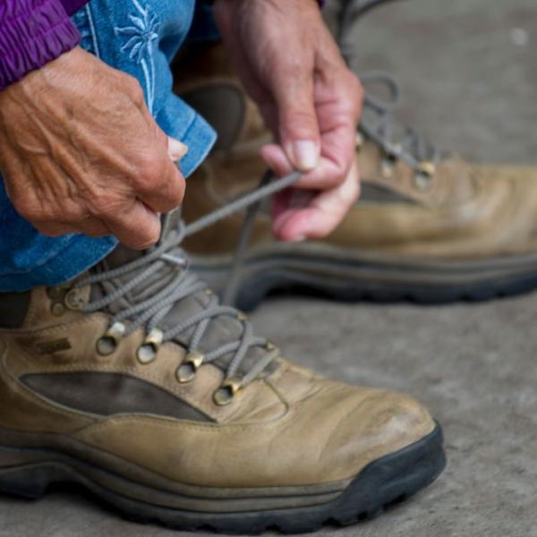 Frau schnürt ihre Wanderstiefel und ist bereit für einen Spaziergang durch Vejle