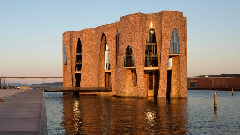 Fjordenhus med sol på ved solnedgang