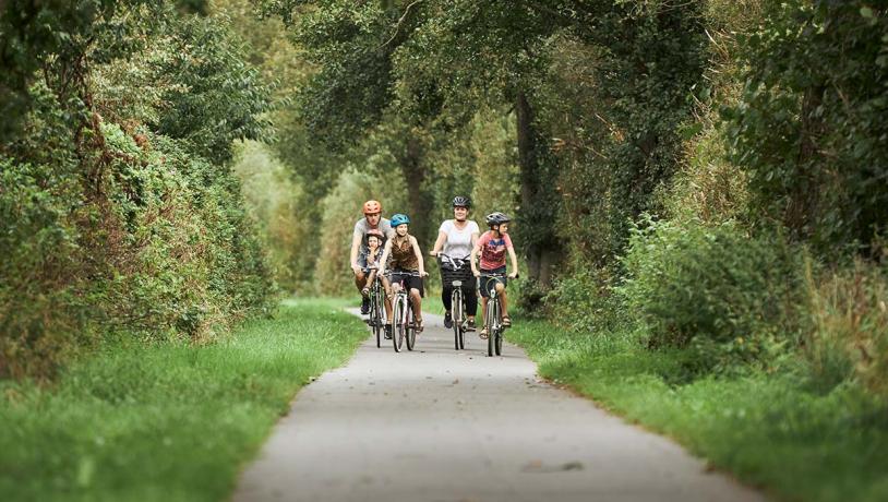 Eine Familie radelt entlang des Bindeballestien in der Nähe von Vingsted
