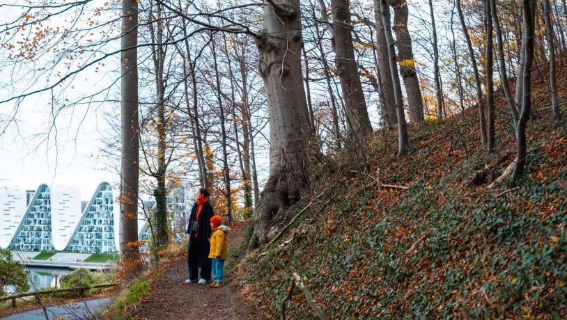 Mutter und Kind bei einem Spaziergang im Nørreskoven in Vejle mit Blick auf Bølgen (Die Welle)