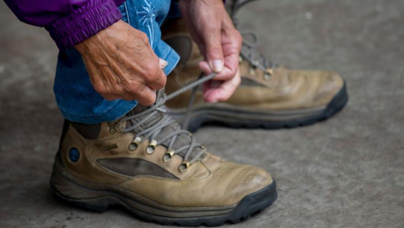 Frau schnürt ihre Wanderstiefel und ist bereit für einen Spaziergang durch Vejle