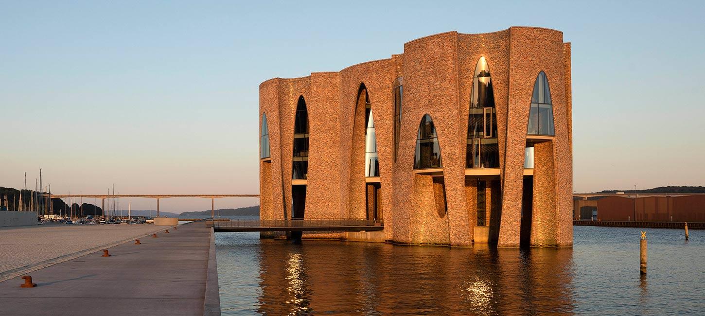 Fjordenhus mit Sonne darauf bei Sonnenuntergang