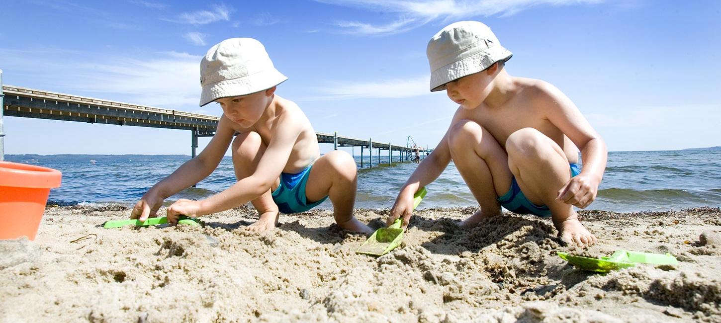 Kinder spielen an einem Sommertag im Sand am Hvidbjerg Strand