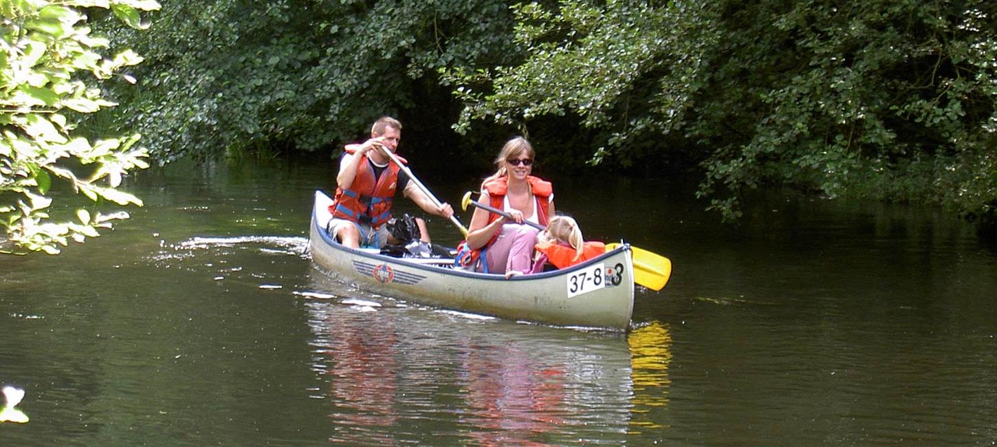 Eine Familie segelt in einem Kanu auf dem Skjern Å