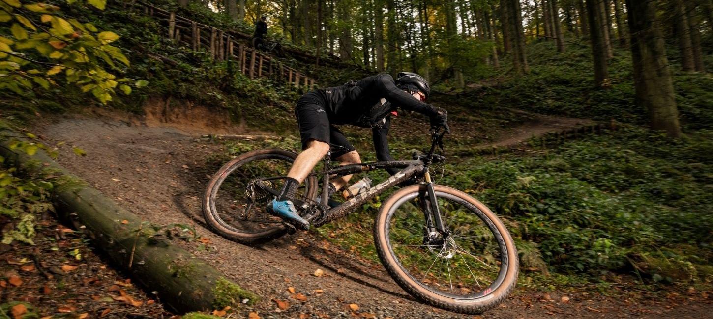 Cykelrytter på vej ned af mountainbike-bakke i Nørreskoven