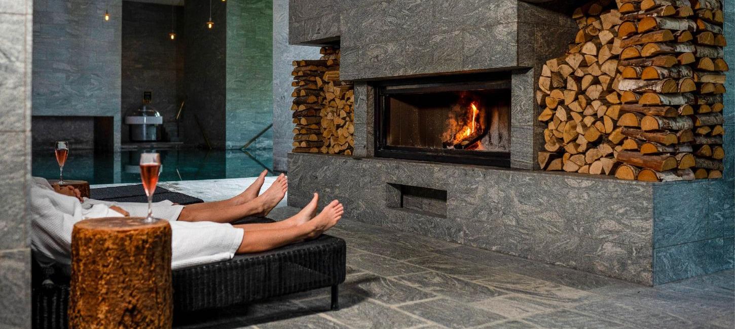 Paar vor dem Kamin mit Wein im Hotel Vejlefjord