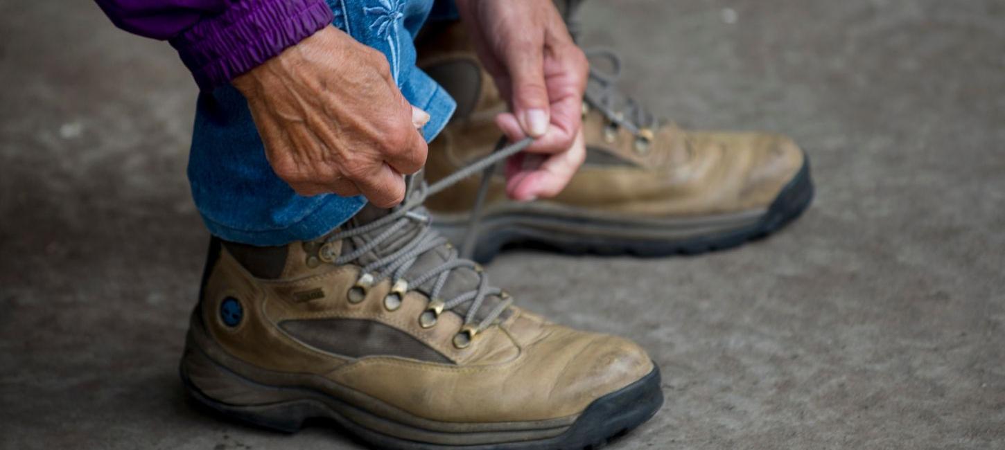 Frau schnürt ihre Wanderstiefel und ist bereit für einen Spaziergang durch Vejle