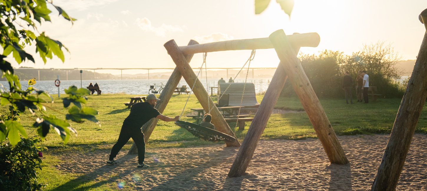 Vater und Kind schaukeln auf dem Spielplatz am Ibæk Strand