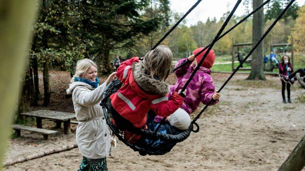 Kinder auf Schaukeln auf dem Waldspielplatz im Sønderskoven in Vejle