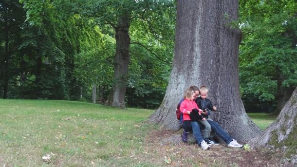 Mor med to børn på natureventyr i skoven