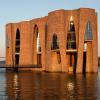 Fjordenhus mit Sonne darauf bei Sonnenuntergang