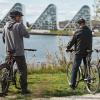 Drei Radfahrer radeln entlang der Ostküstenroute und machen eine Pause am Vejle Fjord und genießen die Aussicht auf Bølgen