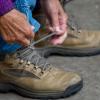 Frau schnürt ihre Wanderstiefel und ist bereit für einen Spaziergang durch Vejle