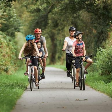 Eine Familie macht an einem Sommertag eine Radtour entlang des Bindeballestien