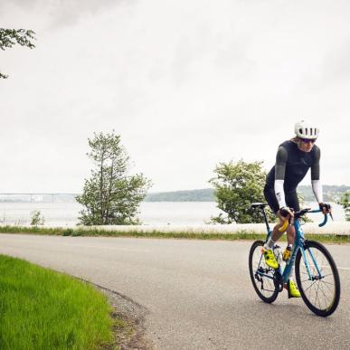 Straßenfahrer sind auf dem Weg zum Munkebjergbakken. Im Hintergrund ist die Vejlefjord-Brücke zu sehen