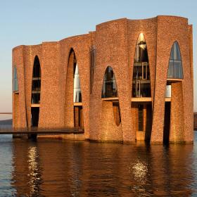 Fjordenhus med sol på ved solnedgang