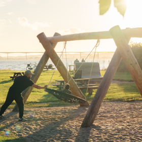 Vater und Kind schaukeln auf dem Spielplatz am Ibæk Strand