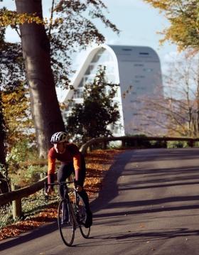 Radfahrer auf einer herbstlichen Radtour im Nørreskoven in Vejle mit dem Bølgen im Hintergrund